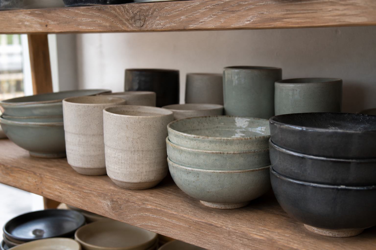 Ceramic pieces drying on shelves in a warm studio